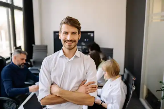 Confident man showcasing Happiness in the workplace in a meeting room with his colleagues